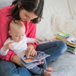 Baby is learning with his mom by colorful book